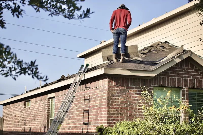 Professional roofer working on a residential roof in Legend Trail